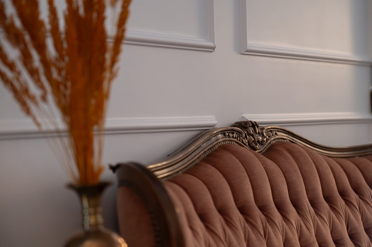 Elegant velvet tufted sofa in a warm, wood-panelled lounge